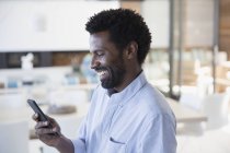 Homem sorrindo mensagens de texto com celular — Fotografia de Stock