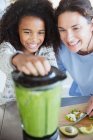 Madre e figlia fanno sano frullato verde nel frullatore — Foto stock