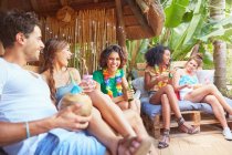 Giovani amici appendere fuori bere e parlare a bordo piscina estate — Foto stock