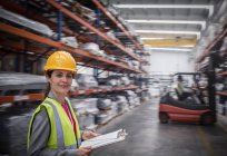 Уверенная в себе, улыбающаяся работница с планшетом на складе — стоковое фото