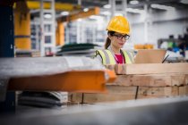 Arbeiterin benutzt Laptop in Fabrik — Stockfoto