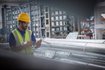 Männlicher Arbeiter mit digitaler Tablette in Stahlfabrik — Stockfoto