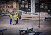 Supervisor and workers talking in warehouse — Stock Photo