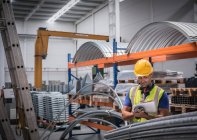 Male supervisor with clipboard in steel factory — Stock Photo