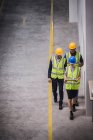 Supervisore e lavoratori con tablet digitale che camminano in fabbrica — Foto stock