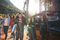 Portrait playful young friends enjoying road trip outside jeep — Stock Photo