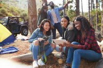 Smiling young women friends using digital tablet at campsite — Stock Photo
