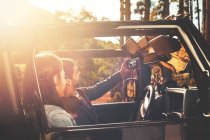 Молода пара з цифровою планшетною камерою бере селфі в джипі в сонячному лісі — стокове фото