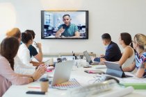 Designers videoconferência com colega em reunião de sala de conferência — Fotografia de Stock
