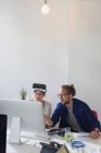 Комп'ютерні програмісти програмують окуляри симулятора віртуальної реальності на комп'ютері в офісі — стокове фото
