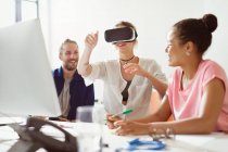 Комп'ютерні програмісти тестують окуляри симулятора віртуальної реальності на комп'ютері в офісі — стокове фото