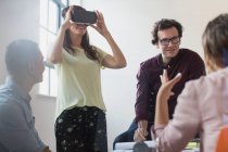 Computer programmers testing virtual reality simulator glasses in open plan office — Stock Photo