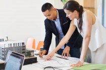 Architects drafting blueprint in office — Stock Photo