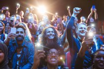 Excited audience with smart phone flashlights cheering — Stock Photo