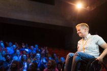 Lächelnde Rednerin im Rollstuhl auf der Bühne — Stockfoto