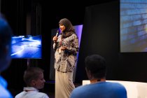 Falante feminina em hijab no palco conversando com o público — Fotografia de Stock