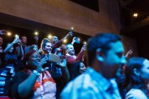 Public enthousiaste avec des téléphones de caméra dans l'auditorium sombre — Photo de stock