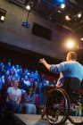 Глядачі спостерігають, як спікер чоловічої статі у інвалідному візку говорить на сцені — стокове фото