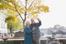 Senior couple taking selfie in front of autumn tree — Stock Photo