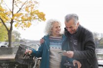 Abenteuerlustiges Seniorenpaar mit Fahrrädern schaut auf Karte — Stockfoto