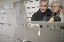 Casal sênior de compras de óculos em loja de optometria — Fotografia de Stock