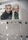 Senior couple shopping for eyeglasses in optometry shop — Stock Photo