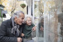 Senior couple window shopping at storefront — Stock Photo