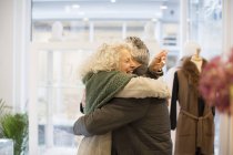 Щаслива старша жінка обіймає чоловіка в ювелірному магазині — стокове фото