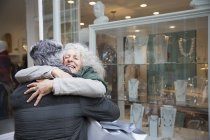 Старша пара обіймає, віконні покупки на фасаді магазину ювелірних виробів — стокове фото