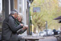 Senior couple drinking coffee at sidewalk cafe — Stock Photo