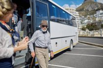 Active senior man tourist disembarking tour bus — Stock Photo