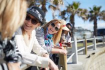 Усміхнені активні старші жінки туристичні друзі розмовляють на сонячній дошці — стокове фото