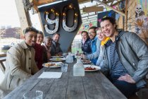 Retrato amigos sorridentes comendo no restaurante pátio ao ar livre — Fotografia de Stock