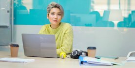 Portrait confident, determined young businesswoman working at laptop — Stock Photo