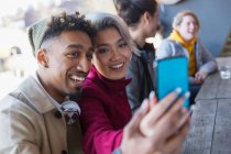 Smiling young couple taking selfie in camera phone — Stock Photo