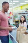 Amistoso cajero ayudando al cliente en la compra del supermercado - foto de stock