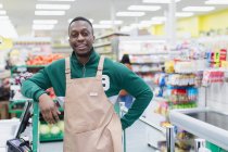 Portrait homme confiant épicier travaillant dans un supermarché — Photo de stock