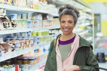 Портрет усміхнений, впевнена жінка купує в супермаркеті — стокове фото