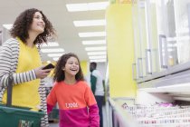 Mãe feliz e filha comprando alimentos congelados no supermercado — Fotografia de Stock