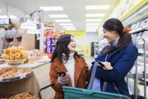 Щасливі жінки друзі купують в супермаркеті — стокове фото