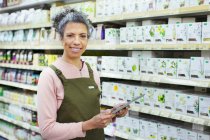 Portrait smiling female grocer with digital tablet working in supermarket — Stock Photo