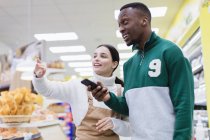 Krämerin hilft Kundin im Supermarkt — Stockfoto