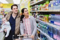 Couple with baby shopping in supermarket — Stock Photo