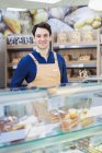 Retrato hombre seguro de sí mismo trabajando en panadería vitrina en el supermercado - foto de stock