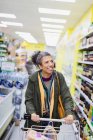 Усміхнена жінка купує в супермаркеті — стокове фото