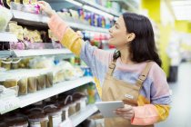 Alimentatore femminile con tablet digitale che lavora nel supermercato — Foto stock