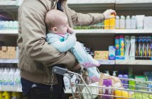 Père avec des achats de bébé au supermarché — Photo de stock