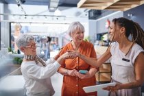 Interior designer shaking hands with women shopping in home decor shop — Stock Photo