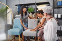 Women shopping for dining chairs in home decor shop — Stock Photo