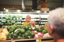 Mulher sênior de compras de tomates na seção de produtos de supermercado — Fotografia de Stock